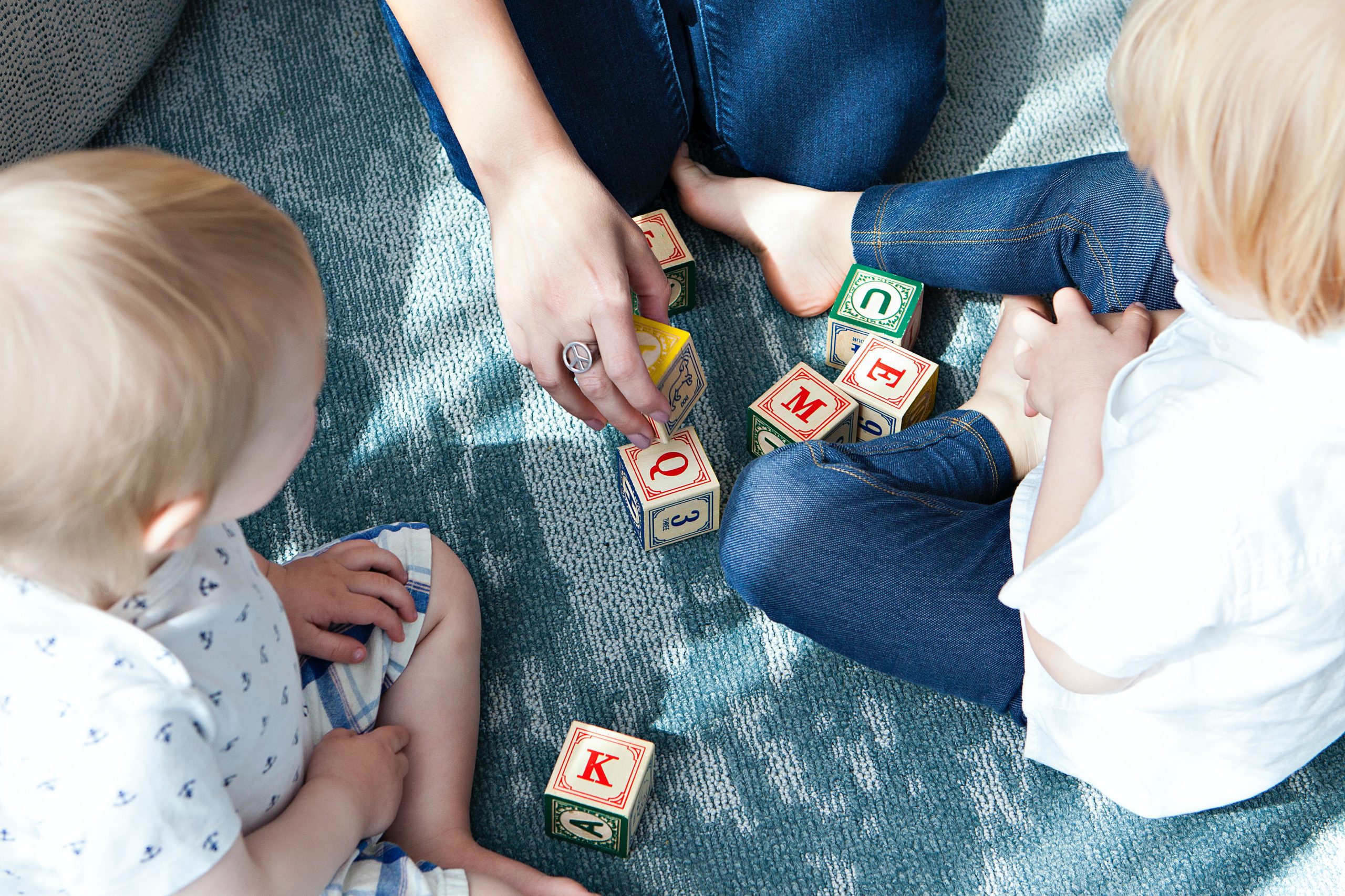 two toddlers playing letter cubes