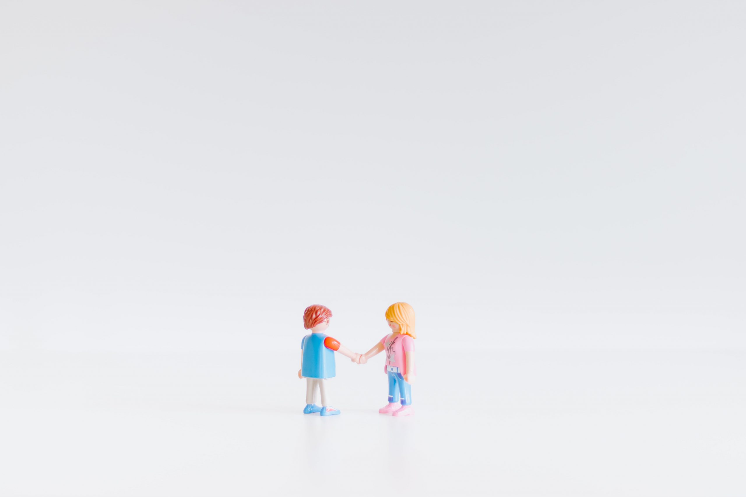 A boy doll and a girl doll holding hands.