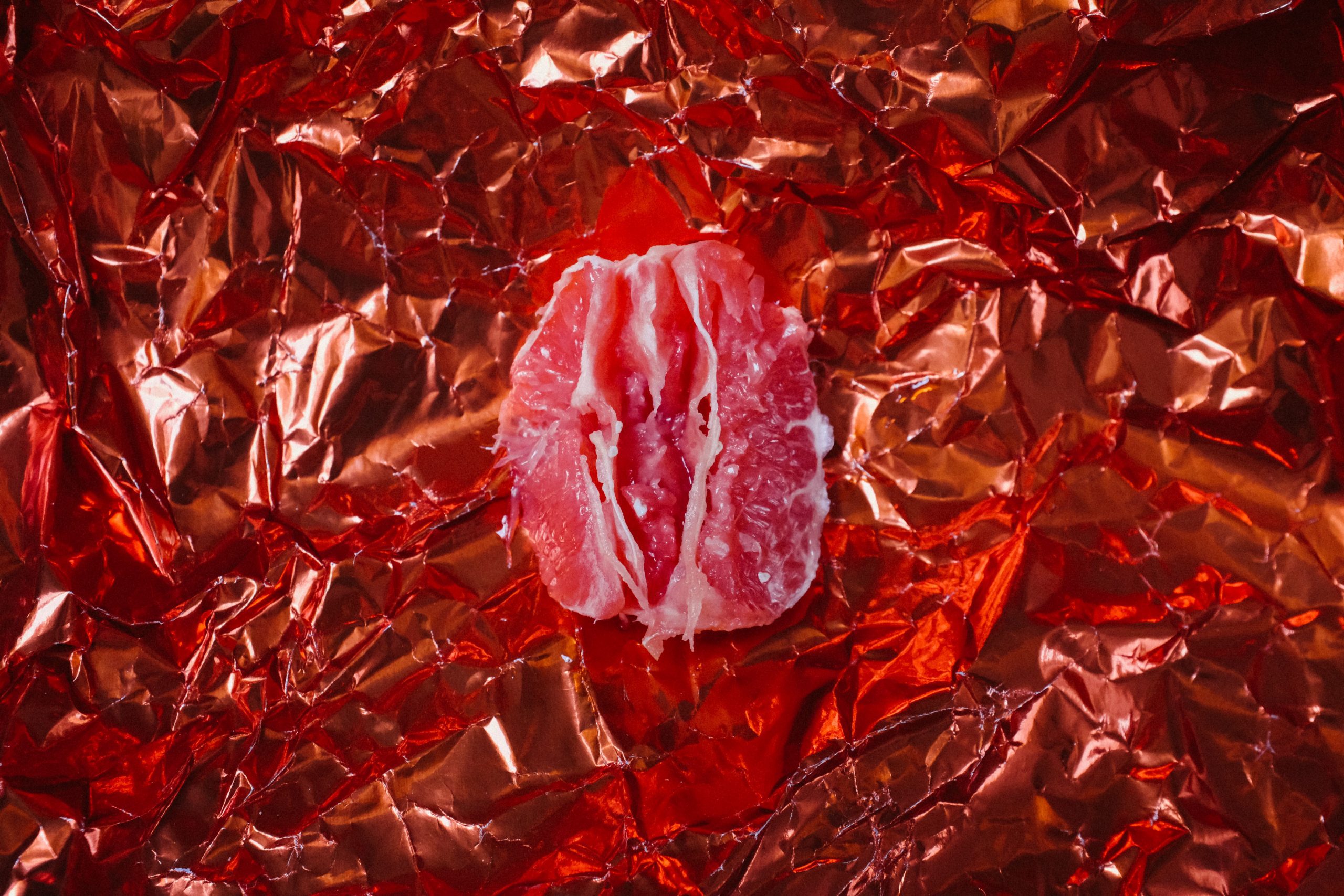 section of grapefruit on a red foil background